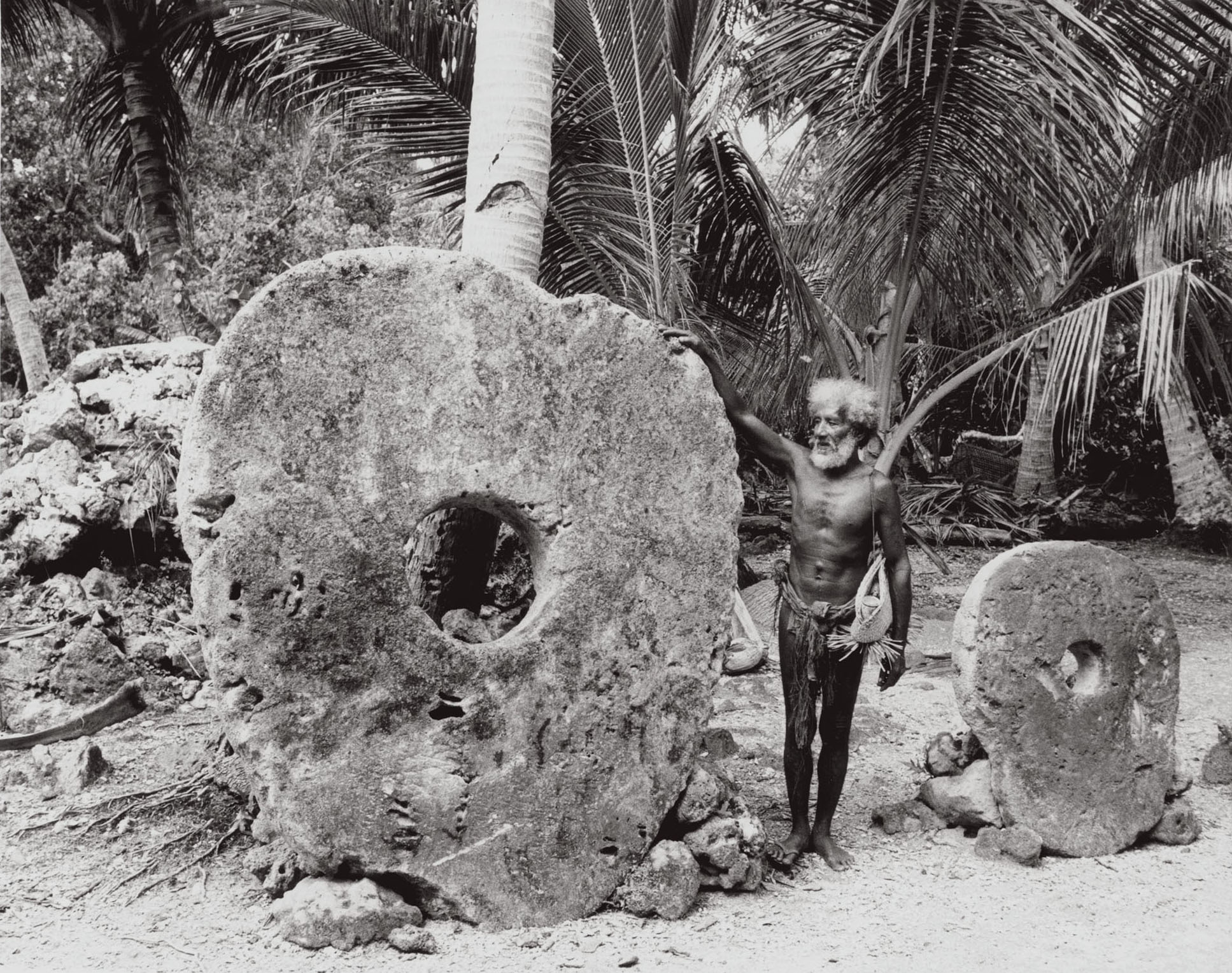 Chief Magistrate Anghel Gargog in costume wearing basket near two coral money discs, 1962. Photographer: Roy H. Goss. National Anthropological Archives, Smithsonian Institution, Washington, D.C.